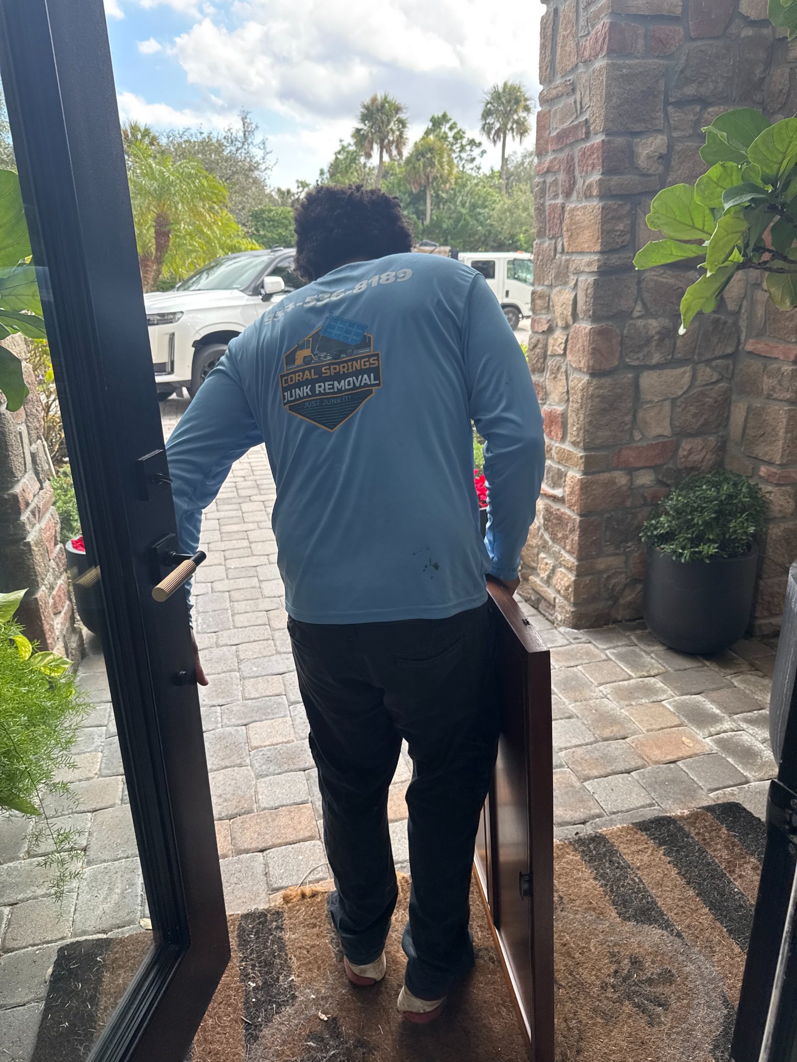 Coral Springs Junk Removal crew member carrying furniture out of a home in Coral Springs FL