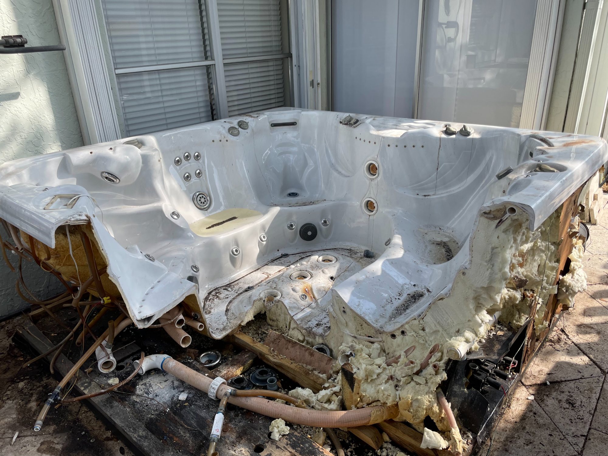Old hot tub dismantled on a patio ready for removal by Coral Springs Junk Removal