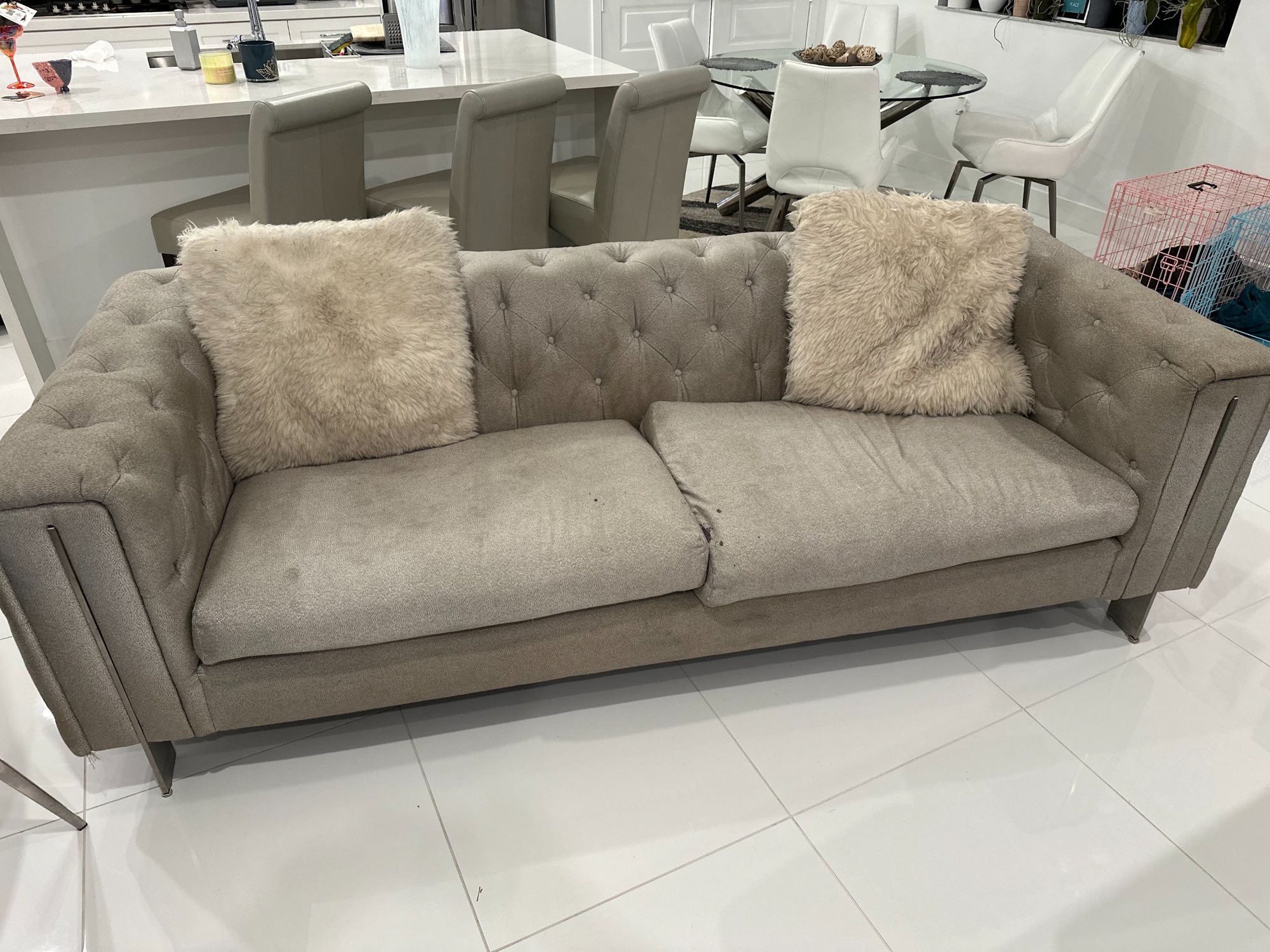 Grey tufted sofa being removed from a Coral Springs FL home by Coral Springs Junk Removal